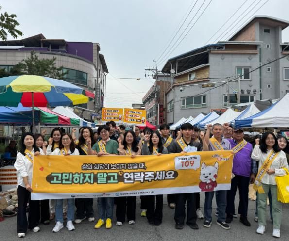 정신보건 담당자들과 유관기관이 함께 청양시장에서 캠페인을 펼치고 있다.