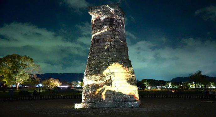 첨성대 외벽에 황금빛 말의 영상이 투사된 미디어파사드 장면.