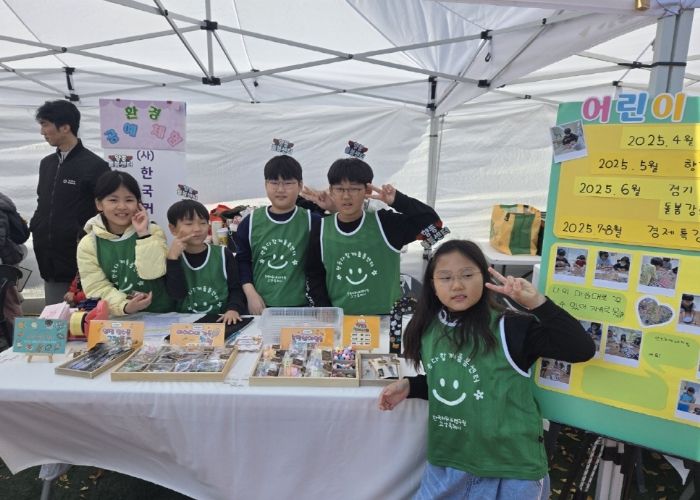 아동창업팀 수공예품 판매 부스에서 아이들이 포즈를 취하고 있다.
