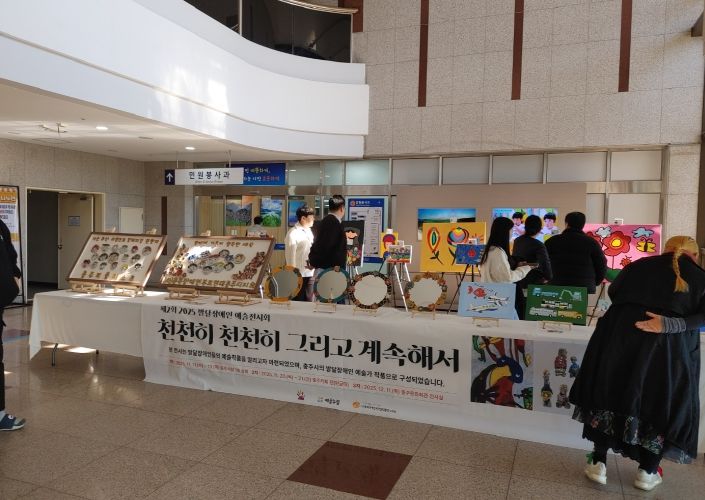 충주시청서 제2회 발달장애인 예술전시회 개최(시민들이 전시회 작품을 보고 있다)