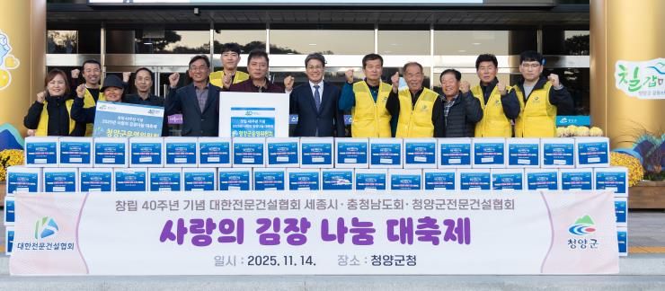 김돈곤 군수와 대한전문건설협회 청양군운영위원회 회원들이 청양군청 앞에서 어려운 이웃을 위해 기탁한 김장김치 100박스를 전달하며 기념 촬영을 하고 있다.