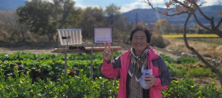 설치된 태양광 외등 앞에서 사진을 찍은 지원 가구