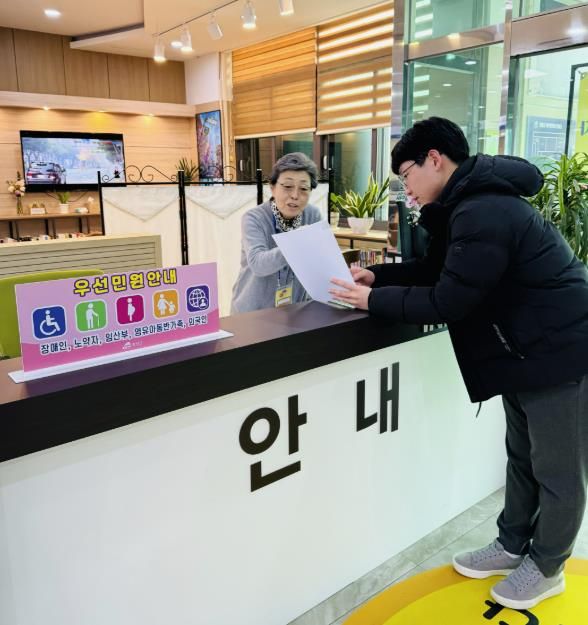 군 행복민원과를 방문한 민원인에게 어르신 민원안내 도우미가 안내를 하고 있다.