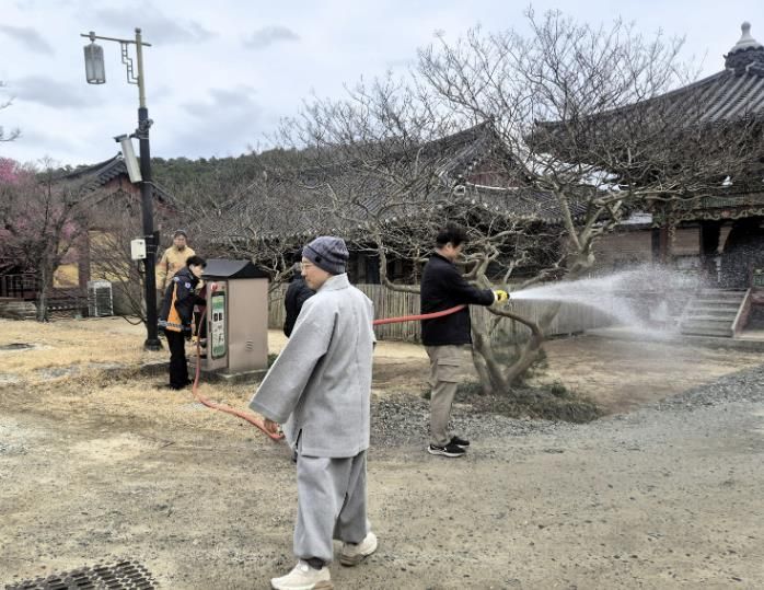 전통사찰 관계자가 비상소화장치를 이용해 직접 방수를 하고 있다.