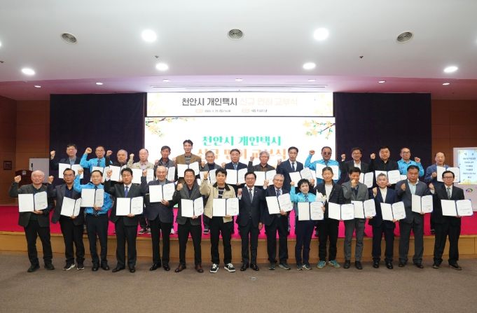 김석필 천안시장 권한대행 부시장이 23일 시청 대회의실에서 열린 개인택시 신규면허 교부식에서 대상자 29명과 함께 안전운전을 다짐하며 기념촬영을 하고 있다.