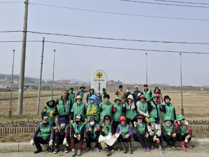 꽃묘 식재 활동에 참여한 새마을지도자둔포면협의회·부녀회원 단체 기념촬영을 하고 있다.