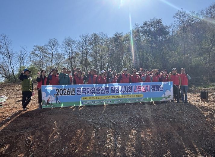 한국자유총연맹 밀양시지회 회원들이 나무심기 행사를 개최하고 기념 촬영을 하고 있다.