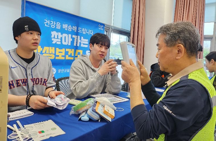 광산구가 14일 호남철도차량정비단에서 찾아가는 상생보건소를 운영했다. 현장 노동자들이 눈 건강 확인을 위해 시력 검사를 하고 있는 모습.